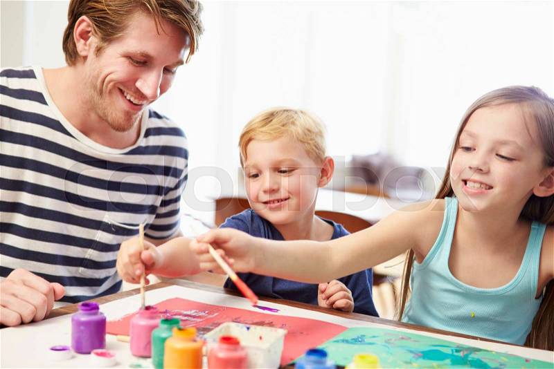 Father Painting Picture With Children At Home, stock photo