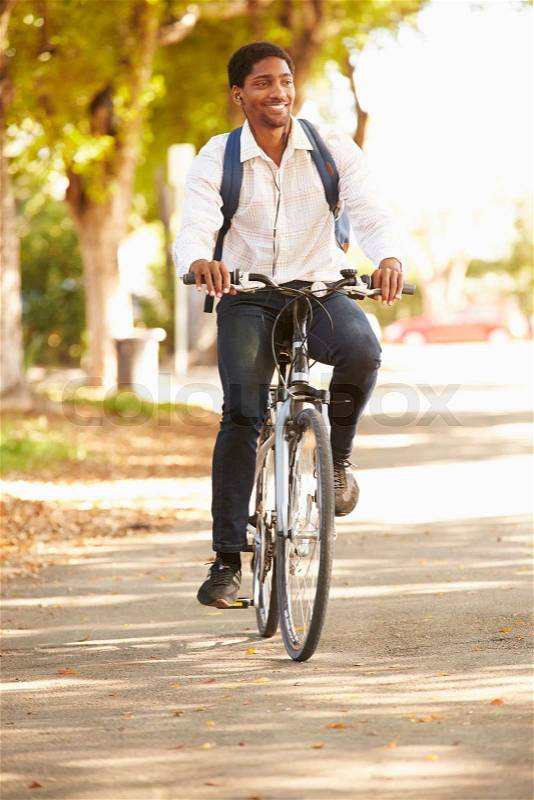 Young Man Cycling Along Street To Work, stock photo