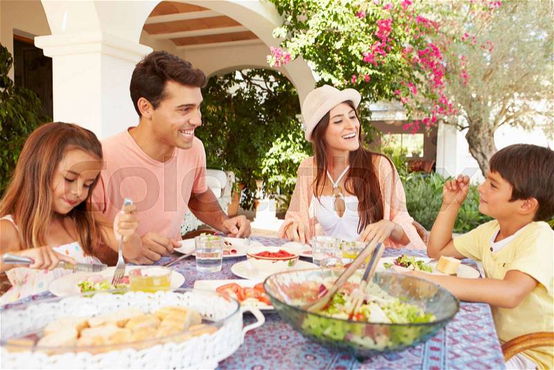 Hispanic Family Enjoying Outdoor Meal At Home Together, stock photo