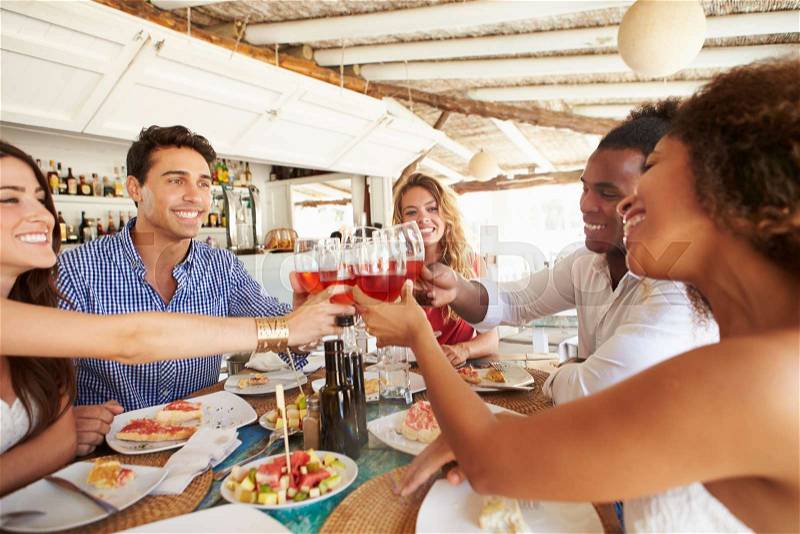 Group Of Young Friends Enjoying Meal In Outdoor Restaurant, stock photo