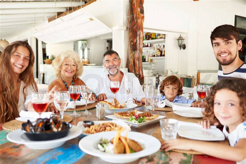 Multi Generation Family Enjoying Meal In Restaurant, stock photo