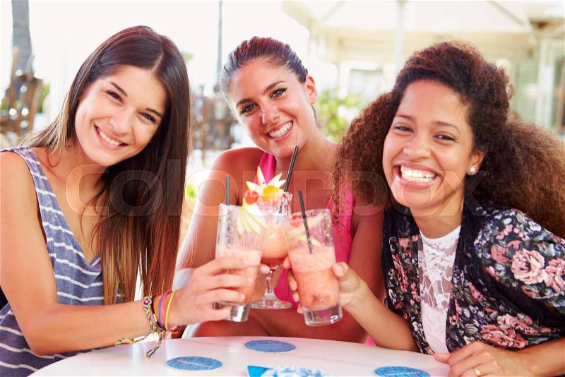 Group Of Female Friends Drinking Cocktails At Outdoor Bar, stock photo