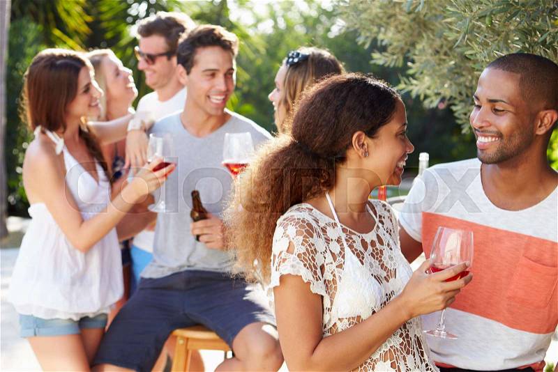 Couple With Friends Drinking Wine And Relaxing Outdoors, stock photo