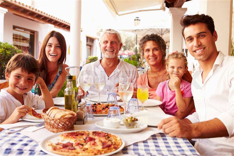 Multi Generation Family Eating Meal At Outdoor Restaurant, stock photo