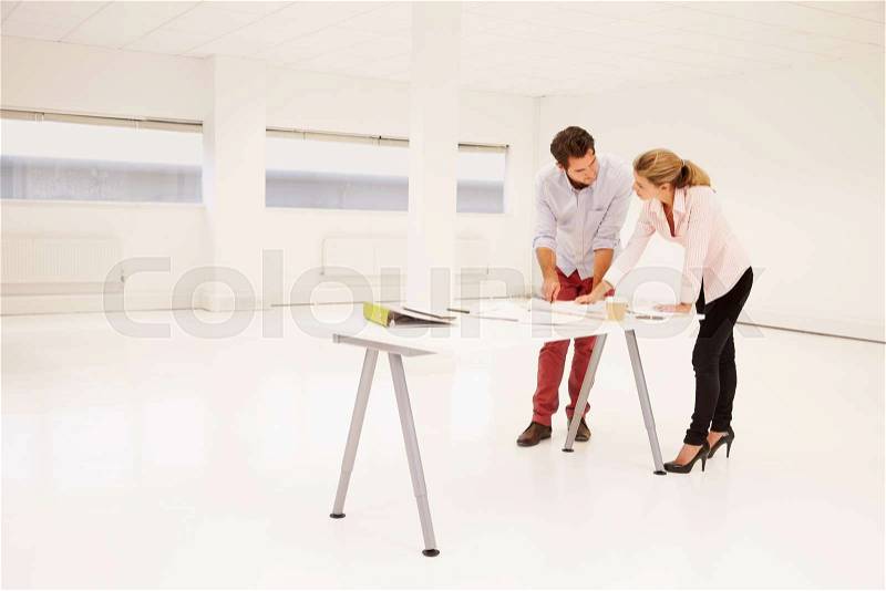 Architects Planning Layout Of Empty Office Space, stock photo