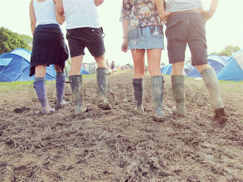 Close Up Of Friends In Wellington Boots Walking To Festival, stock photo