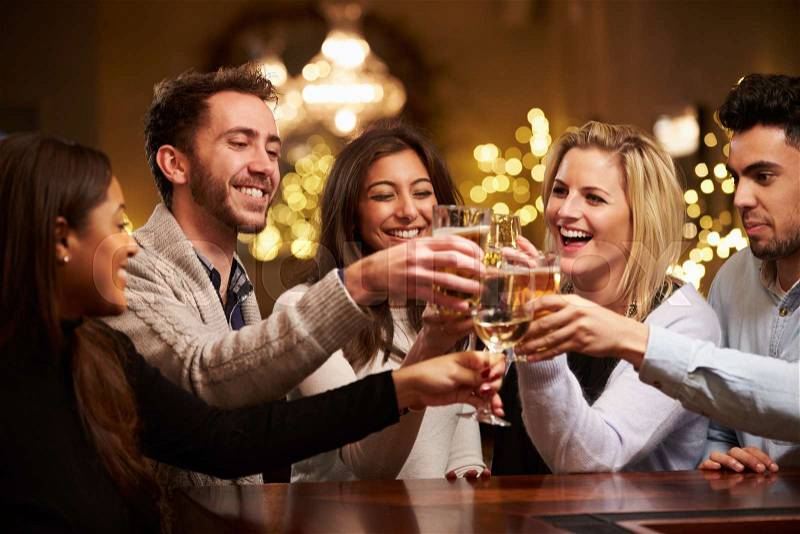 Group Of Friends Enjoying Evening Drinks In Bar, stock photo