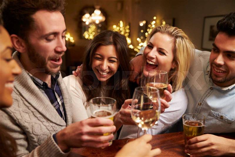 Group Of Friends Enjoying Evening Drinks In Bar, stock photo