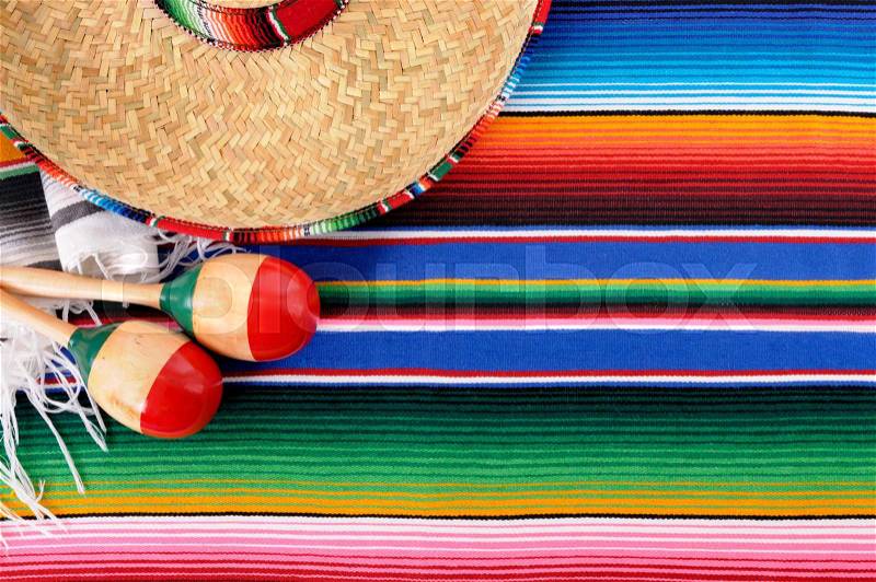 Mexican background with sombrero straw hat, maracas and traditional serape blanket or rug. Space for copy, stock photo