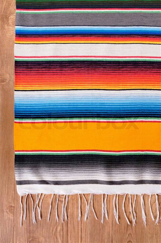 Mexican background with traditional serape blanket or rug on a wood floor. Space for copy, stock photo