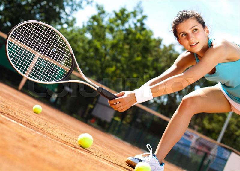 Woman playing tennis in summer, stock photo