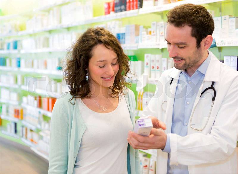 VIew of an Attractive pharmacist advising a patient, stock photo