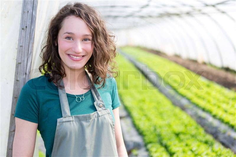 Portrait of an attractive farmer in a greenhouse, stock photo