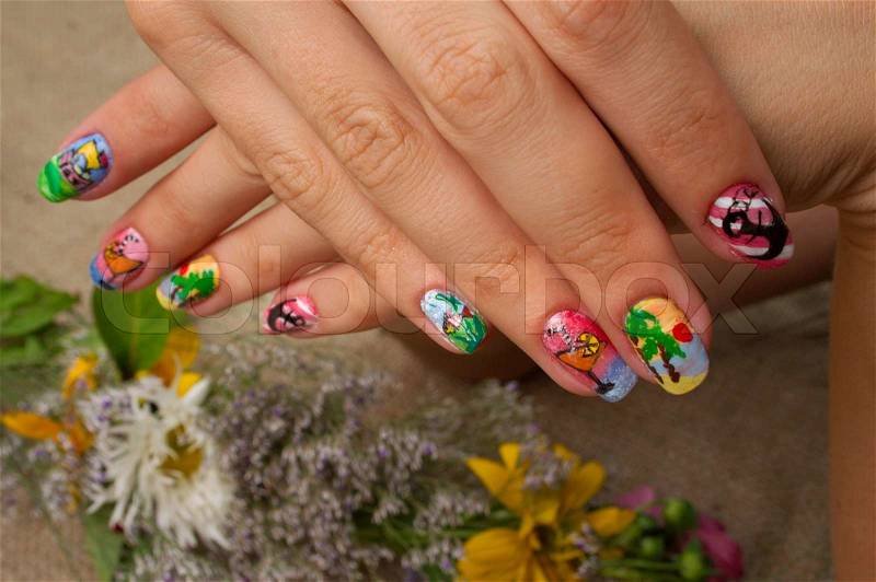 Drawing on nails of unusual figures gives to the woman originality, stock photo