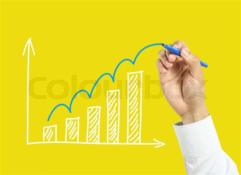 Businessman is drawing growth graph with marker on transparent board with yellow background, stock photo