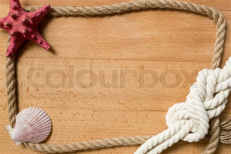 Old wooden boards with rope frame decorated by marine knot and seashells, stock photo