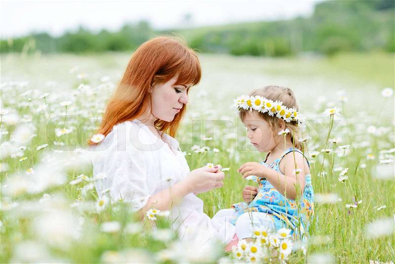 Family having fun in field of daisies, stock photo