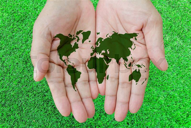 World map in hands with grass background, stock photo