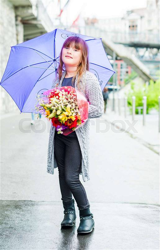 Outdoor portrait of a cute little girl with purple umbrella in a city, stock photo