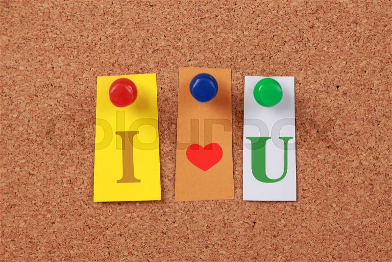 The text \'I love U\' in cut out magazine letters pinned to a corkboard, stock photo