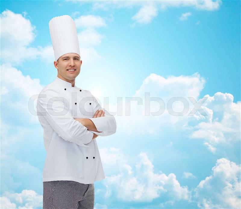 Cooking, profession and people concept - happy male chef cook with crossed hands over blue sky with clouds background, stock photo