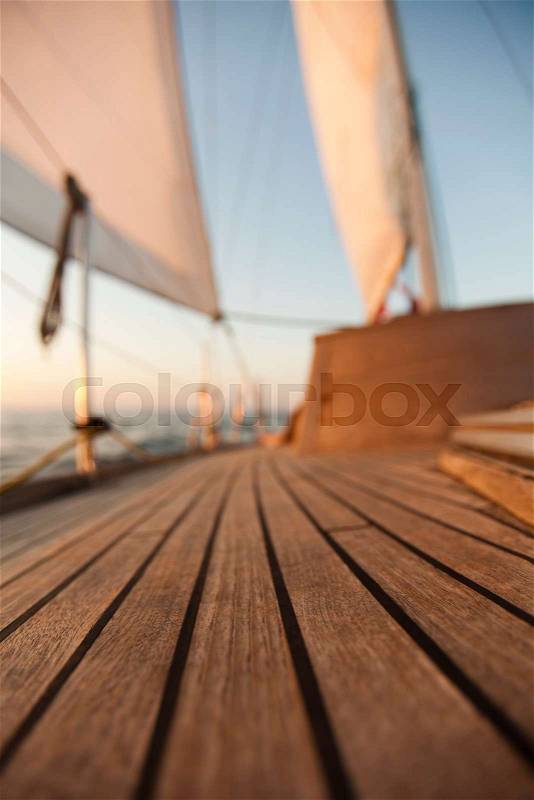 Large winch with line wrapped around and set sail in background, stock photo