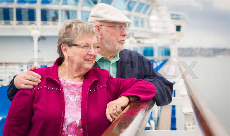 Happy Senior Couple Enjoying The View From Deck of a Luxury Passenger Cruise Ship, stock photo