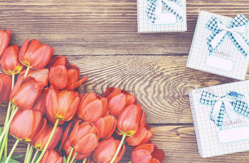 Bouquet of Fresh Orange Tulip Flowers on Top of Wooden Table with Three Gift Boxes, Captured in High Angle View, stock photo