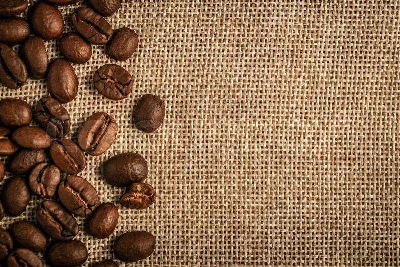 Coffee beans border over burlap sack background. Lots of copy space for edit, stock photo