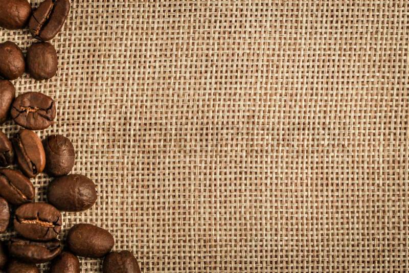 Coffee beans border over burlap sack background. Lots of copy space for edit, stock photo