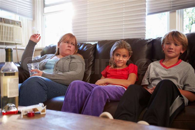 Mother Sits On Sofa With Children Smoking And Drinking, stock photo