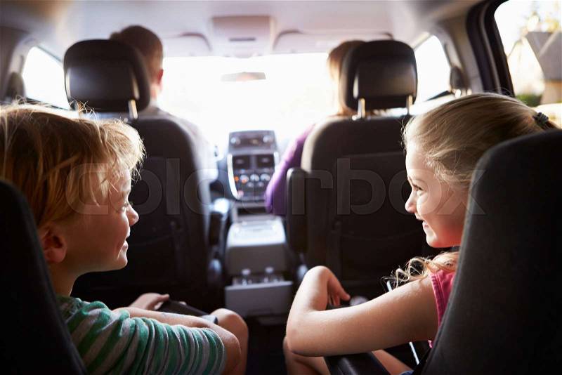 Children In Back Seat Of Car On Journey With Parents, stock photo