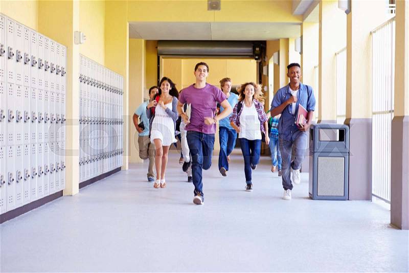 Group Of High School Students Running In Corridor, stock photo