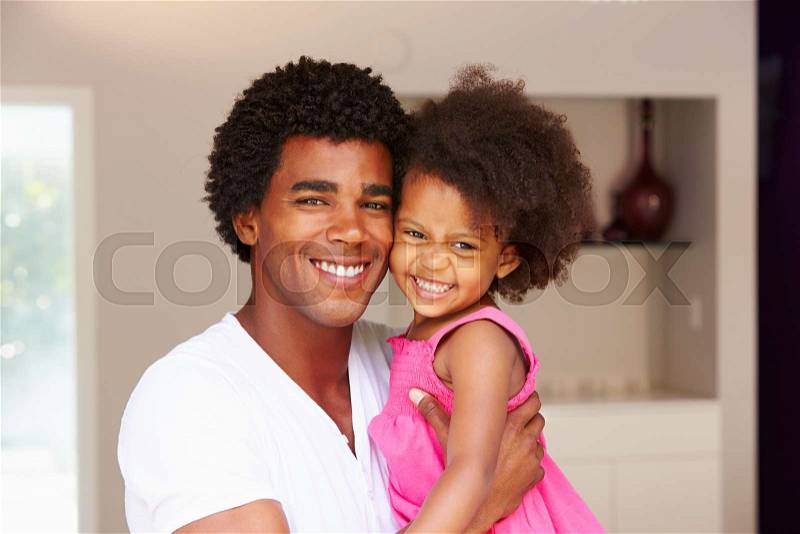 Dad Cuddling Daughter At Home, stock photo