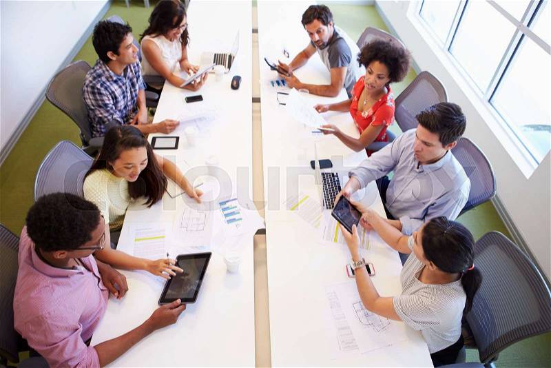Overhead View Of Designers Meeting To Discuss New Ideas, stock photo