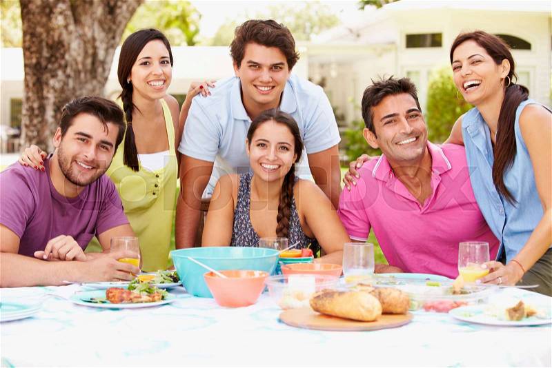 Group Of Friends Celebrating Enjoying Meal In Garden At Home, stock photo
