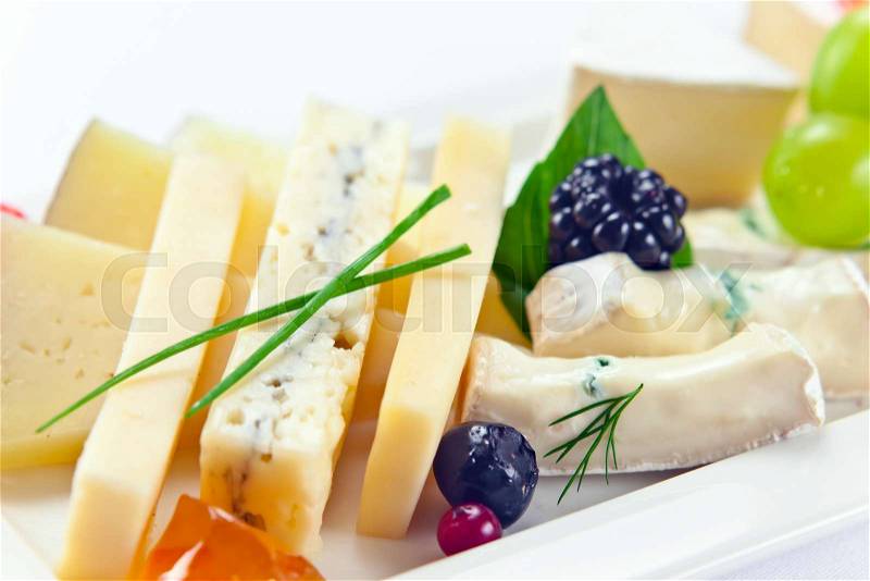 Cheese with berries on a white plate, stock photo