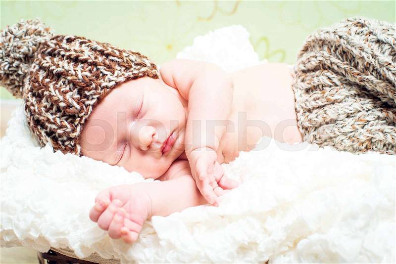 Beautiful newborn baby boy sleeping in knitted cap, stock photo