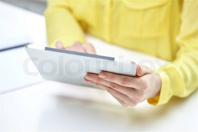 People, technology and internet concept - close up of female hands with tablet pc at table, stock photo