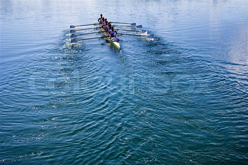 Boat coxed eight Rowers rowing on the tranquil blue lake, stock photo