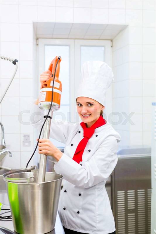 Female Chef preparing ice cream with food processor in gastronomy parlor kitchen, stock photo
