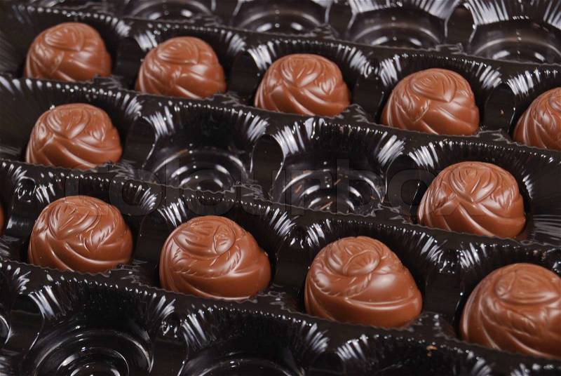 Chocolates in a box of black colour. A dessert, stock photo