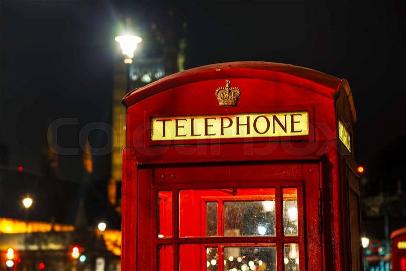 Famous red telephone booth in London, UK at night, stock photo