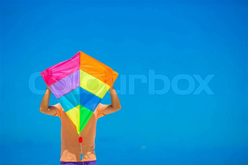 A young man with a kite on a background of turquoise sea, stock photo