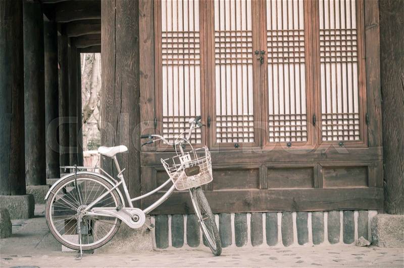 Bicycle parking against asian style house vintage color processed filter, stock photo