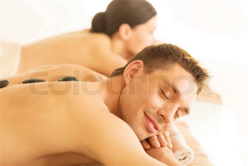 Picture of couple in spa salon with hot stones, stock photo