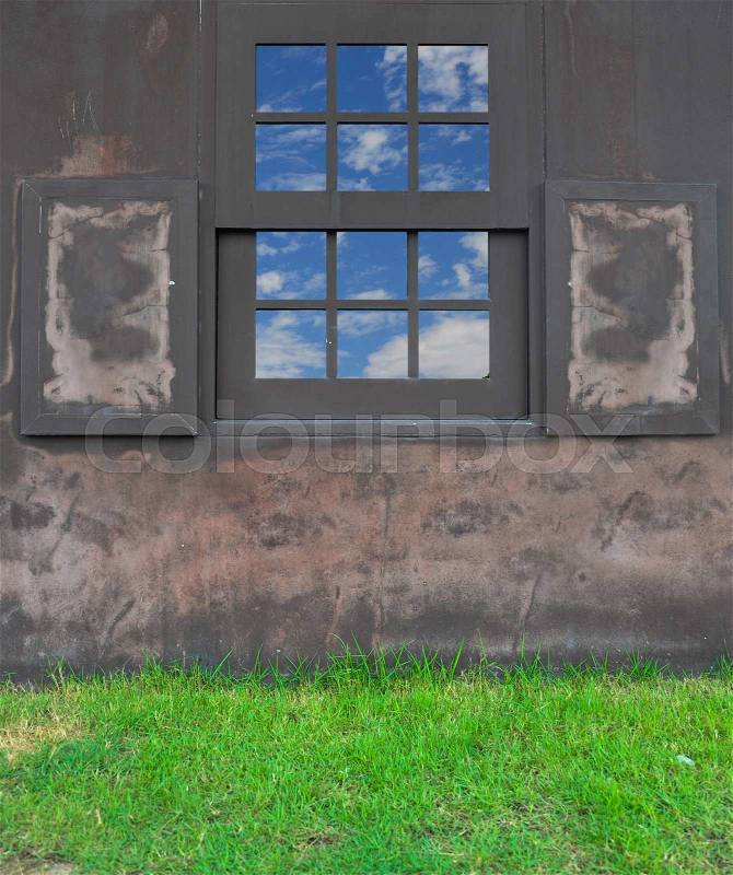Window on waving brown wall with grass\, stock photo