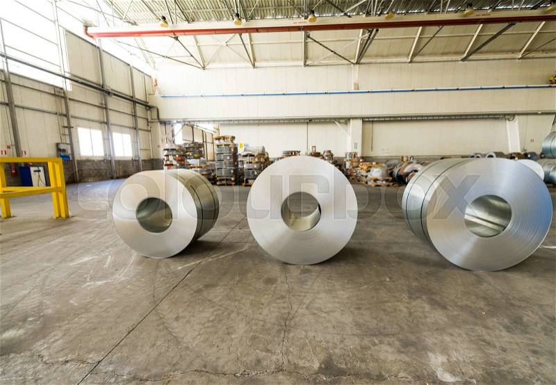 Cold rolled steel coils in storage area ready to feed to machine in metalwork manufacturing, stock photo