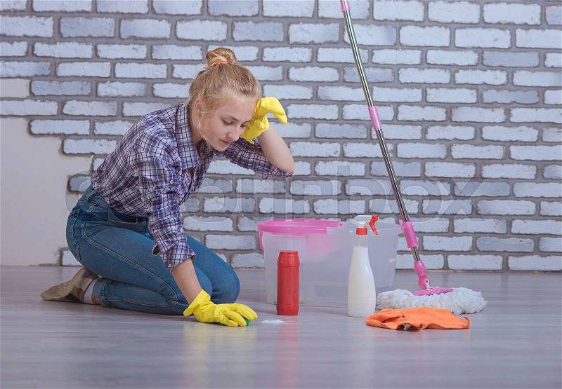 Beautiful girl washes the floors in the apartment, stock photo
