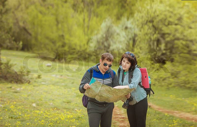Tourists with a map in the forest, stock photo